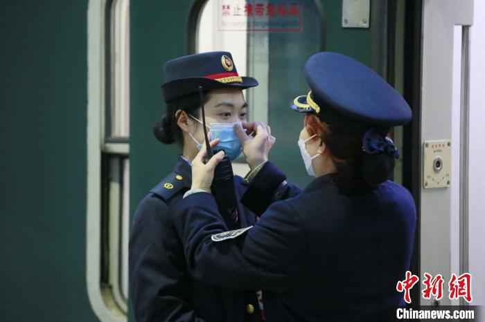 母亲杨春蓉正在为女儿李斯羊调整口罩。 李锴 摄 铁路人战“疫”:面对疫情,母女并肩前行