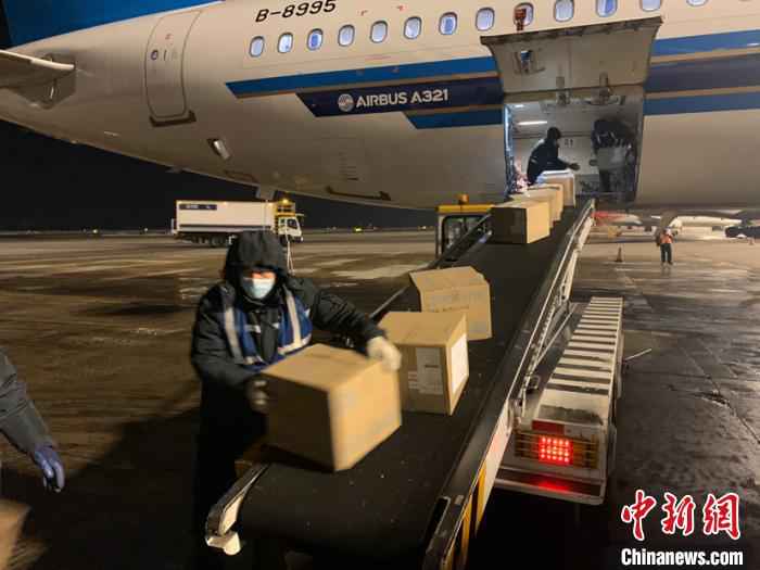 图为机场工作人员搬运物资。(吕品摄) 史轶夫 摄 24吨各类防疫物资运抵中国北疆