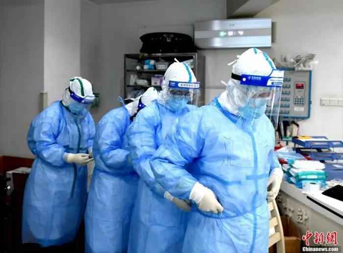 3月8日是国际妇女节,在武汉市红十字会医院里,来自四川、河北、上海等多支医疗队的女医护人员依旧奋战在抗“疫”一线。图为护士们在做进病区的防护工作。安源 摄 天使,节日快乐!